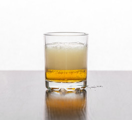 Beer in a glass mug stands on a table on a white background.