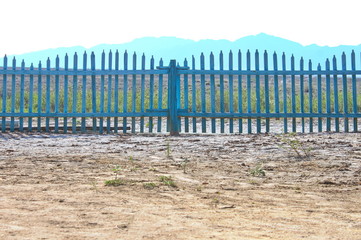 blue fence against the backdrop of a mountain range, Altyn- Emel Nature Park, Kazakhstan, 2018.
