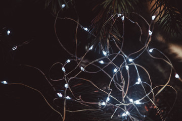 Christmas tree garland glows with bright bulbs on the Christmas tree.