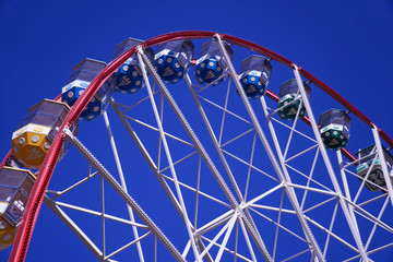 Carousel. Ferris Wheel on a blue background. Carriages of the big wheel