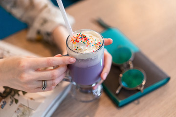 cup of coffee in girl hand on the table