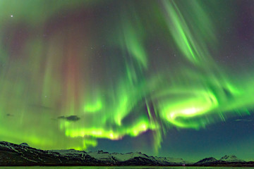 Level 5 Aurora rising above a beautiful mountain. In iceland