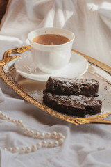 Morning coffee with chocolate cake. Sunny morning. Black coffee in white mug.