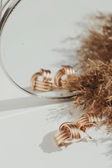 trendy yellow earrings on white background. Earrings in the mirror. Fashion
