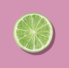 Green lime slices on vibrant pink color background. Minimal summer concept. flat lay food texture