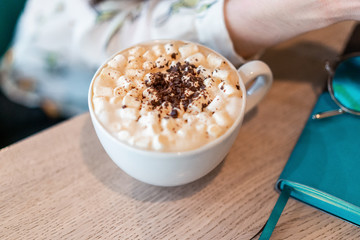 cup of coffee in girl hand on the table
