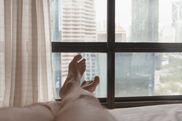 Bare feet of a man lying in a bed