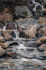 Water flows over stones. Waterfall at long exposure. Kola Peninsula. North of Russia.