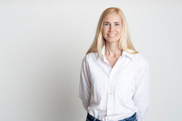 Indoor portrait of beautiful blonde middle-aged lady smiling