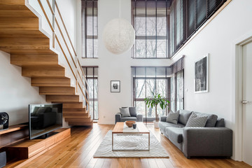 Spacious living room with wooden stairs - 331213478