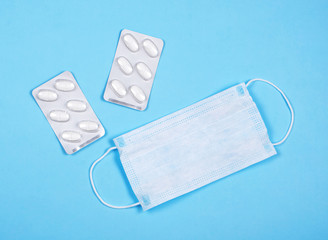 P revention of c oronavirus. Medical masks, vitamins on a blue background.