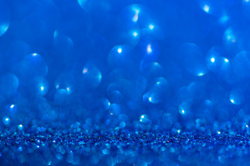 Glitter, sparkle defocused blurred blue background with bokeh lights