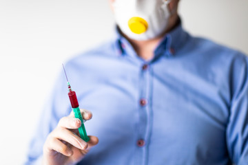 Pandemia COVID-19, lekarz w masce trzymający strzykawke na testy