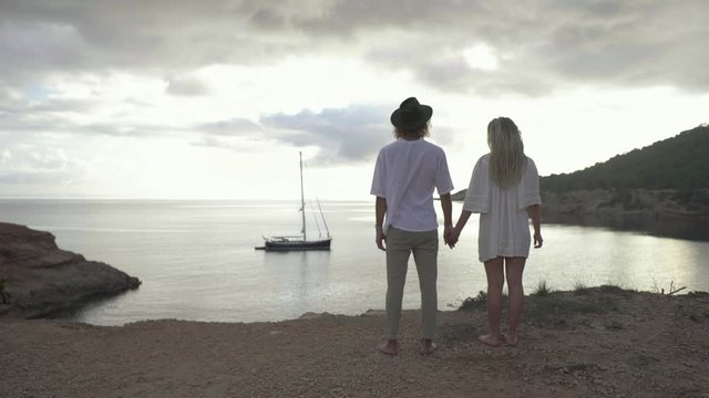 Slow motion shot of couple holding hands and enjoying view