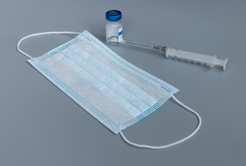 medical mask and injection a gray background