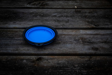 A blue cup lid on a wooden surface