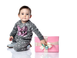 Portrait of child opening gift box in white studio