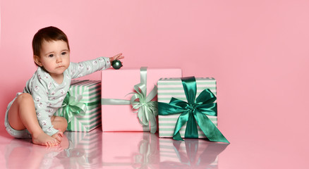 baby girl sitting on the floor with gift box