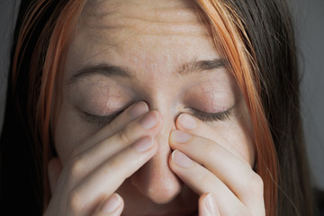 Touching face with fingers - concept of bringing virus or infection. Woman trying to sneeze or...