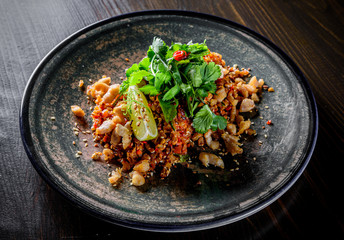 Fried rice with chicken and vegetables in plate on wooden table background