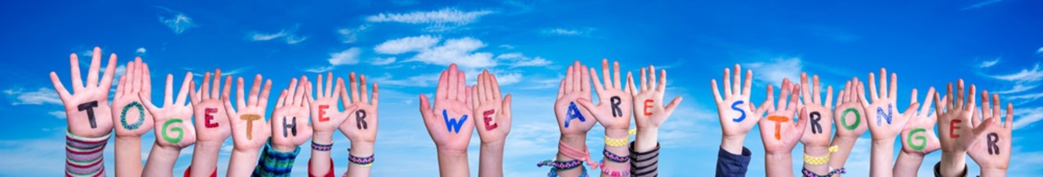 Children Hands Building Colorful Word Together We Are Stronger. Blue Sky As Background