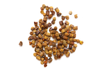 Bee pollen pellet pieces called ambrosia on white background.