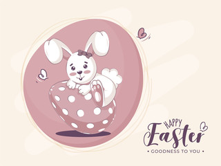 Happy Easter, Goodness To You Font with Cartoon Bunny Climbing on Painted Egg.