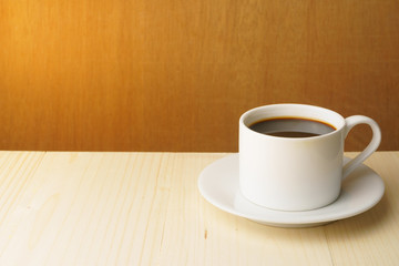 coffee cup on wooden table against wood background. free copy space for your text