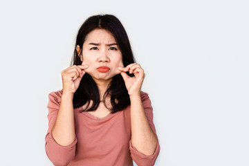 unhappy Asian woman hand pulling her fat skin on cheeks ,aging and overweight concept