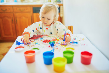 Adorable little girl painting with fingers