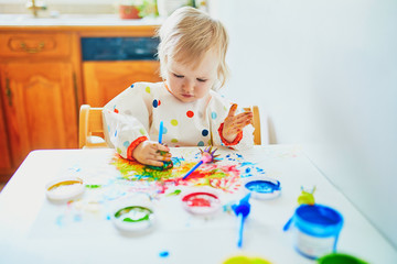Adorable little girl painting with fingers