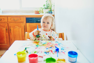 Obraz na płótnie Canvas Adorable little girl painting with fingers