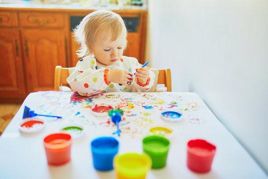 Adorable little girl painting with fingers