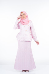 Full length portrait of a beautiful female model wearing traditional dress and hijab, a lifestyle apparel for Muslim women isolated on white background. Idul Fitri and hijab fashion concept.