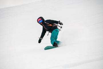 Fototapeta na wymiar Girl snowboarder moving down in snow powder
