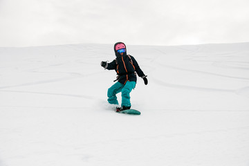 Fototapeta na wymiar Freerider snowboarder moving down in snow powder