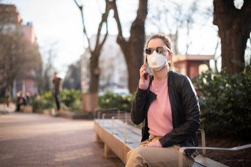Fototapeta premium Young woman wearing a respirator mask in the city during the coronavirus outbreak