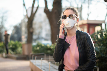Young woman wearing a respirator mask in the city during the coronavirus outbreak