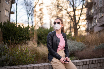 Shot of young woman wearing a respirator mask while on the street