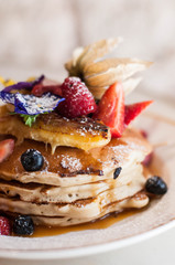 Pancakes with berries and edible flowers