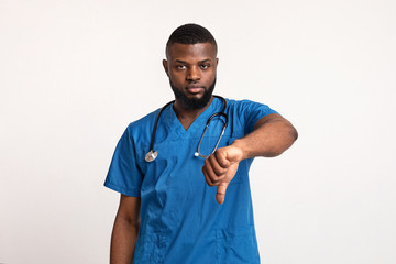 Serious young black doc showing thumbs down