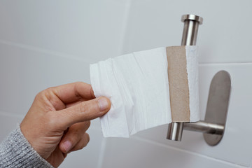 man getting the last piece of toilet paper