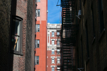 Fototapeta premium Alleyway with Old Residential Buildings and Skyscrapers in Morningside Heights of New York City