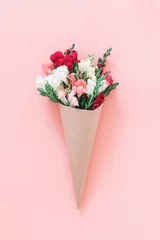 Wall murals Roses bouquet in cone on pink background, flat lay, top view.