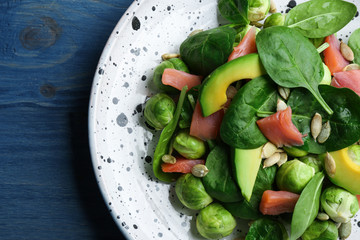 Tasty salad with Brussels sprouts on wooden table, top view