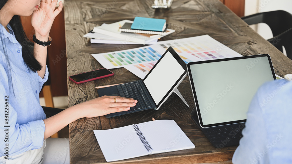 Aufkleber cropped image of graphic designer team working together with computer tablet and color guide/informa