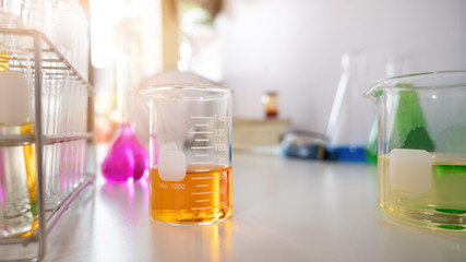 Photo of Scientific equipment and chemistry glassware putting together on white working desk over laboratory white wall as background.