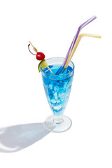 Blue Lagoon cocktail with ice cubes is contained in a milkshake glass with two straws, a lime slice and a cherry on the stick. The showy illustrative picture is made on the white background.