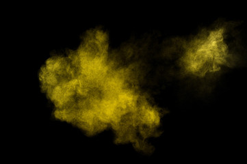 Yellow powder explosion on black background. Colored powder cloud. Colorful dust explode. Paint  Holi.