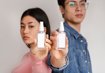 Sanitizing Spray Bottles In Hands Of Millennial Chinese Couple, Mockup
